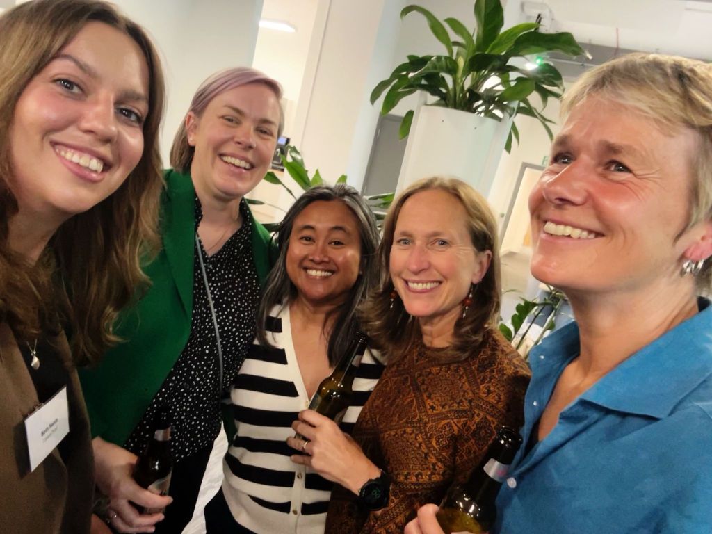 A selfie of Equalise colleagues smiling and holding drinks in their hands