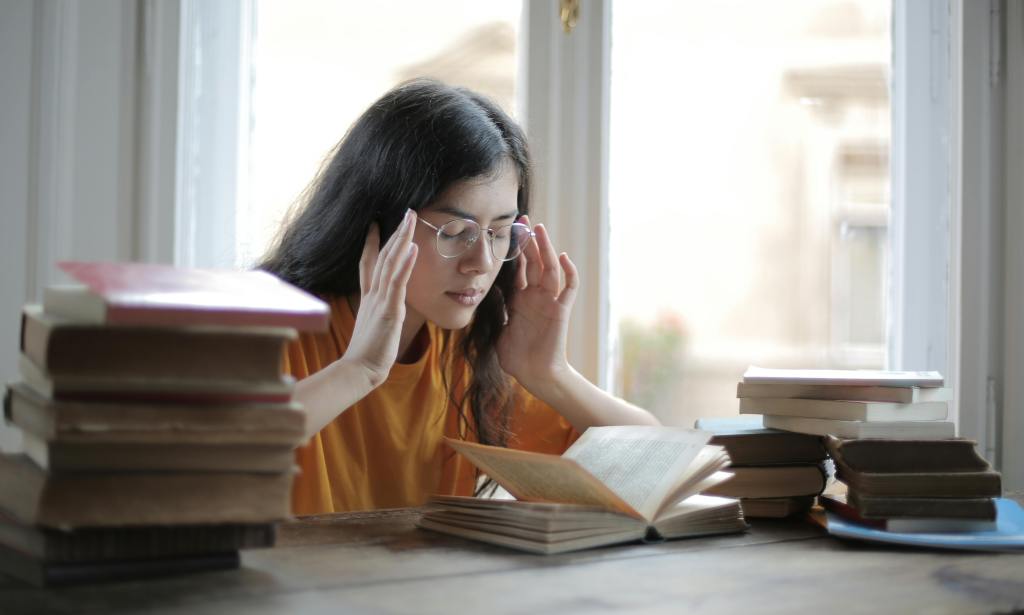 A student concentrating to study , with books surrounding them