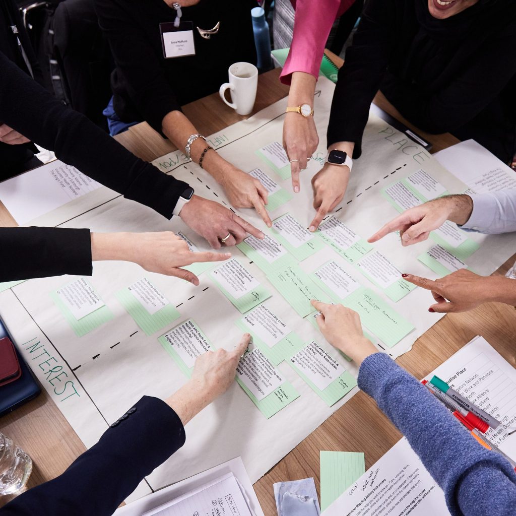 A view from the top of hands pointing at notes and papers.