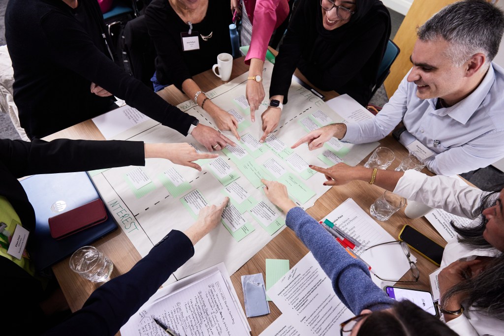 A view from the top of hands pointing at notes and papers.